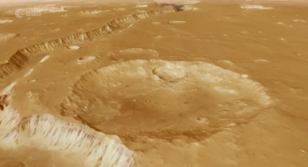 Eiropas Kosmosa aģentūra (ESA) publicējusi satriecošu video, kas ļauj skatītājiem “izlidot” virs seno ūdens straumju iezīmētā Marsa reģiona Xanthe Terra. Video tapis, izmantojot Mars Express orbītas zondes augstas izšķirtspējas kameras (HRSC) datus, kas vairāk nekā 20 gadus vāc informāciju par Sarkanās planētas virsmu. Senas upes gultnes un “haosa” ainavas Video centrālais objekts ir Shalbatana Vallis – dziļa ieleja aptuveni 1300 kilometru garumā, pa kuru pirms miljardiem gadu plūduši milzīgi ūdens apjomi no Marsa dienvidu augstienes uz ziemeļu līdzenumiem. Lidojuma laikā redzamas arī t.s. “haosa zonas” – savdabīgi, erozijas veidoti reljefi ar plato tipa salām un izlocītiem kalniem. Video noslēgumā skatītājus sagaida Da Vinči krāteris, kura diametrs sasniedz 100 kilometrus. Trīsdimensionāls ceļojums pa senu Marsu Video papildināts ar 3D reljefa modeli, kas balstīts uz topogrāfiskiem datiem, un atmosfēriskiem efektiem, lai skatījums būtu pēc iespējas reālistiskāks. Tas ļauj ieraudzīt senā Marsa klimatiskās pēdas – vietas, kur reiz plūda ūdens, veidojot kanjonus, deltas un plašas ielejas. Mars Express — 20 gadu ilgs darbs orbītā Mars Express ir vienīgais ESA aktīvais aparāts uz Marsa orbītas, un tas jau vairāk nekā divas desmitgades turpina atklāt planētas ģeoloģiskos un klimatiskos noslēpumus. Jaunākais video ne tikai parāda Marsa skaistumu, bet arī atgādina, cik dziļi un spēcīgi ūdens reiz ietekmējis šīs planētas virsmu.