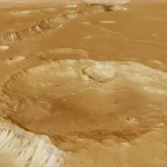 Eiropas Kosmosa aģentūra (ESA) publicējusi satriecošu video, kas ļauj skatītājiem “izlidot” virs seno ūdens straumju iezīmētā Marsa reģiona Xanthe Terra. Video tapis, izmantojot Mars Express orbītas zondes augstas izšķirtspējas kameras (HRSC) datus, kas vairāk nekā 20 gadus vāc informāciju par Sarkanās planētas virsmu. Senas upes gultnes un “haosa” ainavas Video centrālais objekts ir Shalbatana Vallis – dziļa ieleja aptuveni 1300 kilometru garumā, pa kuru pirms miljardiem gadu plūduši milzīgi ūdens apjomi no Marsa dienvidu augstienes uz ziemeļu līdzenumiem. Lidojuma laikā redzamas arī t.s. “haosa zonas” – savdabīgi, erozijas veidoti reljefi ar plato tipa salām un izlocītiem kalniem. Video noslēgumā skatītājus sagaida Da Vinči krāteris, kura diametrs sasniedz 100 kilometrus. Trīsdimensionāls ceļojums pa senu Marsu Video papildināts ar 3D reljefa modeli, kas balstīts uz topogrāfiskiem datiem, un atmosfēriskiem efektiem, lai skatījums būtu pēc iespējas reālistiskāks. Tas ļauj ieraudzīt senā Marsa klimatiskās pēdas – vietas, kur reiz plūda ūdens, veidojot kanjonus, deltas un plašas ielejas. Mars Express — 20 gadu ilgs darbs orbītā Mars Express ir vienīgais ESA aktīvais aparāts uz Marsa orbītas, un tas jau vairāk nekā divas desmitgades turpina atklāt planētas ģeoloģiskos un klimatiskos noslēpumus. Jaunākais video ne tikai parāda Marsa skaistumu, bet arī atgādina, cik dziļi un spēcīgi ūdens reiz ietekmējis šīs planētas virsmu.